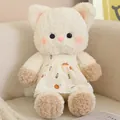 Adorable cream plush cat toy wearing a yellow patterned dress on a soft beige sofa - Cat