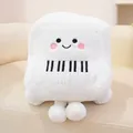 Adorable white piano shaped plush toy with cartoon smiling face on a soft beige sofa - Piano Style