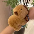Adorable bracelet claque en peluche capybara marron porté au poignet d'une personne. - Bracelet claquant / 20cm / Marron