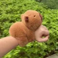 Detailed view of a soft furry brown capybara plush slap bracelet worn on a wrist - Capybara