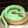 Realistic green plush snake toy for pranks and home decor displayed on a woven straw cushion - Agate Green Python / 110 cm