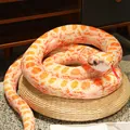 Realistic orange and white patterned snake plush toy coiled on straw cushion - Orange-white Python