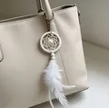 Llavero mini atrapasueños blanco con plumas colgando de un elegante bolso de cuero beige - Estilo Pluma Blanca (MS6978B) / Blanco