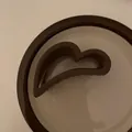 Dettaglio di una pinza per capelli marrone opaca a forma di cuore dalla finitura liscia - Grande Pinza a Cuore