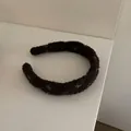 Vista detallada de una diadema acolchada de hilo bouclé marrón oscuro para mujer - Caqui