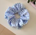Detail shot of a blue plaid scrunchie featuring delicate light blue lace edge trim - Blue Stripe Lace Scrunchie / Blue