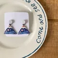 Cute Mount Fuji acrylic drop earrings with cherry blossom design on white plate. - Blue Mountain Peak