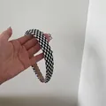 Close-up van een stijlvolle 2 cm brede hoofdband met een zwart-wit geruit patroon - Klein (Nummer 2) / Brede Rand / Zwart Wit Geblokt