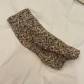 Detalle que muestra el estampado floral vintage en manguitos de protección solar de gasa - Floral Naranja