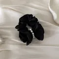 Elegant black satin hair scrunchie with white pearl detail on cream silk background - Hair Tie