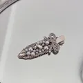 Close-up detail of luxury silver hair clip with white pearls and sparkling rhinestones - Pearl Bow - Non-Marking Clip