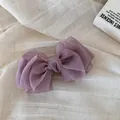 Vista detallada del lazo de organza violeta multicapa sobre un fondo de lino suave - Pinza Banana con Lazo / Púrpura
