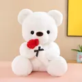 Close-up of white teddy bear plush toy holding a red rose with black polka dot bow detail - Holding Rose (White) / S