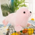 Primer plano lateral de un peluche de foca rosa apoyado en una cesta decorativa negra - 25cm / Rosa