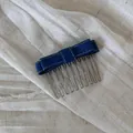 Close-up of a blue denim bow hair comb with yellow stitching on white linen fabric. - Light Blue Denim - Double Layer Bow Hair Comb