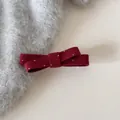 Gros plan d'une barrette à nœud en feutre bordeaux à pois blancs sur un mohair - Barrette / Rouge