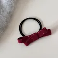Gros plan d'un chouchou à nœud en feutre bordeaux avec un délicat motif à pois blancs élégant - Cravate à cheveux / Rouge