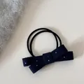 Gros plan détaillé montrant la texture douce d'un joli nœud pour cheveux à pois. - Cravate à cheveux / Bleu