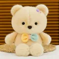 Primo piano dettagliato di un simpatico orsetto di peluche crema con farfallino colorato. - Orso Candy / 25cm