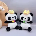 Close-up of two cute mini panda plush dolls with yellow caps and colorful bells - Panda / 23cm