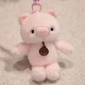 Adorable pink plush pig keychain with a very soft texture and a stylish fashion tag. - Pink Pig