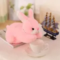 Detailed view of a soft pink plush bunny toy resting on a white table surface. - 25cm / Pink
