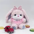 Close-up detail of a soft pink plush rabbit toy with bow tie and embroidered bib - 22cm / Pink Puffy Rabbit