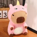Detailed view of a cute capybara plush toy wearing a pink unicorn costume on a wooden desk. - Capybara Unicorn Costume / 23cm