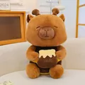 Detail view of a cute Capybara plush toy holding a honey pot in a warm home setting. - Capybara Holding Honey Pot / 25cm / Brown
