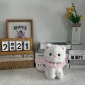 Detailed view of a white plush cat doll with a pink lace collar in a cozy home setting - 22cm / White