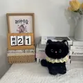 Detailed macro view of a cute black cat plush toy with a decorative yellow lace collar. - 22cm / Black