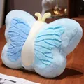 Détail de profil d'un coussin en peluche papillon bleu sur table en bois - Bleu / 21cm