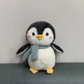 Detaillierte Nahaufnahme eines weichen Plüschpinguins mit einem grünen Strickschal - Grau Schal Pinguin / 22cm