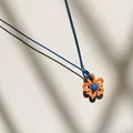 Nahaufnahme eines farbenfrohen Blumenanhängers aus Harz an einer blauen Kordelkette. - Oranges Blütenblatt Blaue Kordel / Orange