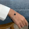 Primo piano di bracciale di perle minimalista con perline d'argento e perla nera centrale - Bracciale / Perla Nera Argento Frantumato