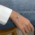 Nahaufnahme eines eleganten Silberperlenarmbands mit einer großen grauen Perle am Handgelenk. - Armband / Crushed Silver Graue Perle