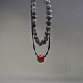 Vista macro dettagliata della collana a doppio strato con pietre naturali sfaccettate e perla rossa - Set Perline Marroni Anello Rosso