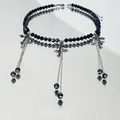 Dettaglio della collana girocollo con perle nere, nappe d'argento e ciondoli a croce - Collana con Croce in Cristallo Nero e Nappine