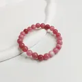 Detaillierte Draufsicht auf ein 8mm rosa Naturkristall-Perlenarmband auf weißem Tablett - 8mm Erdbeerrosa