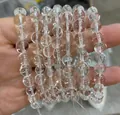 Hoogwaardige transparante kristallen kralenarmband vastgehouden in een hand getoond - 7A Natuurlijke Bergkristal Stijl / 7-9mm / Wit/Helder