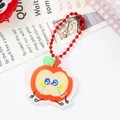 Close-up detail of a cute apple-shaped acrylic keychain with a vibrant red ball chain - Crying Apple (2088)