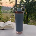 Detail shot of a grey outdoor shaker bottle with protein storage base on a table - 591ml / Gray