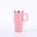 Detail view of a pink stainless steel insulated car tumbler with handle and straw. - 14oz / Pink