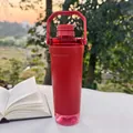 Large red sports shaker bottle shown in an outdoor lifestyle setting with a book. - 591ml / Red