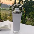 Detailed view of white shaker bottle with handle and storage base in outdoor setting - 591ml / White