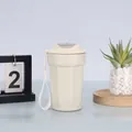 Detailansicht einer beigen achteckigen Kaffeetasse aus Edelstahl mit Trageschlaufe in heller Umgebung. - 450ml / Weiß