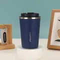 Nahaufnahme eines mattblauen Thermobechers mit sicherem schwarzem Klappdeckel auf einem Ständer - 380ml / Blau