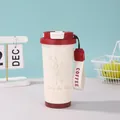 Detail der cremefarbenen 316 Edelstahl-Kaffeetasse mit Maiglöckchen-Muster und Tragegurt - 500ml / Rote Maiglöckchen