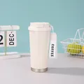 Detailansicht der cremefarbenen 316-Edelstahl-Kaffeetasse mit tragbarem Tragegurt - 500ml / Weiß