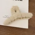 Detailed close-up of a soft beige fuzzy lambswool hair claw clip on paper background - Plush Hair Claw / White